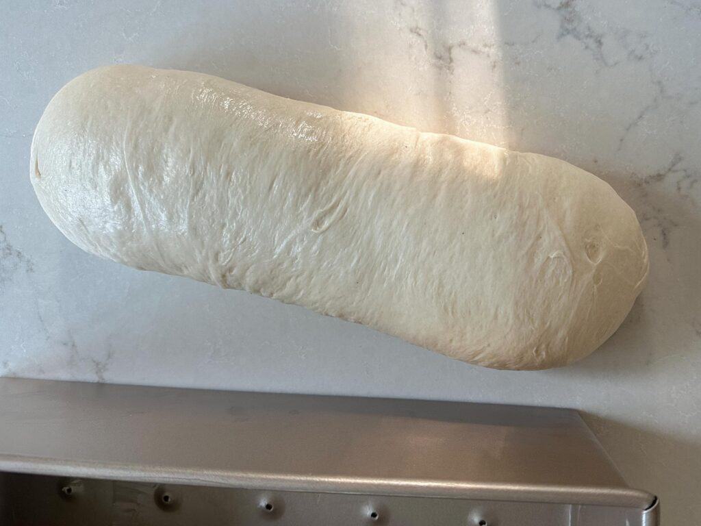 Pain de mie sourdough bread dough shaped into a loaf after bulk fermentation