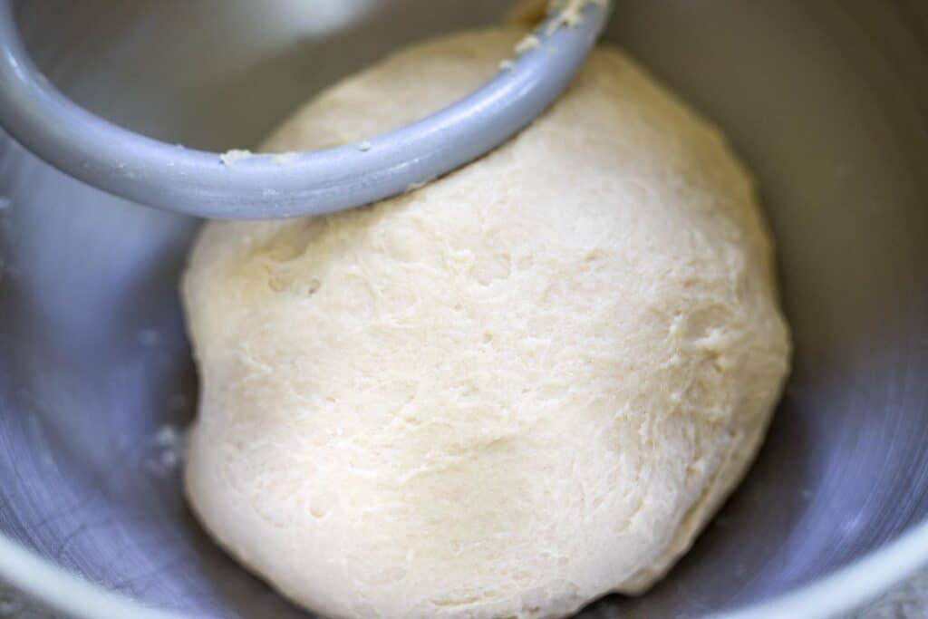 dough in a stand mixer bowl with a dough hook