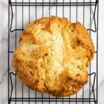 overhead photo of a loaf of sourdough Irish soda bread on a wire rack