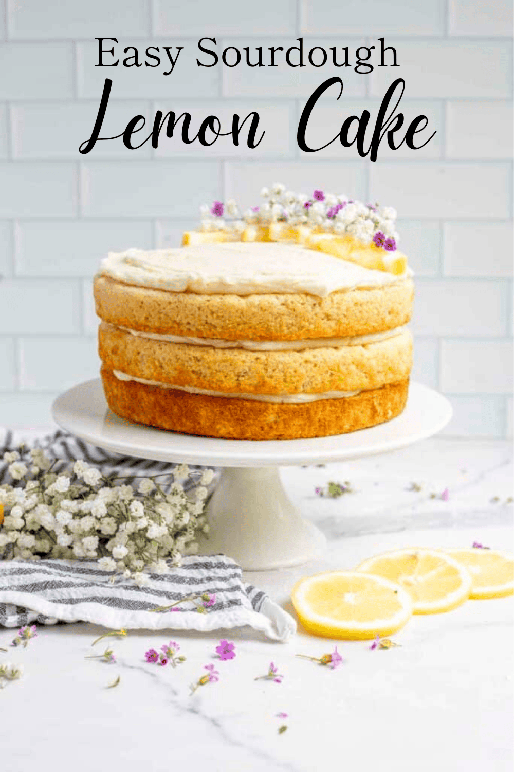 A multilayered sourdough lemon cake with white icing on a white cake platter.