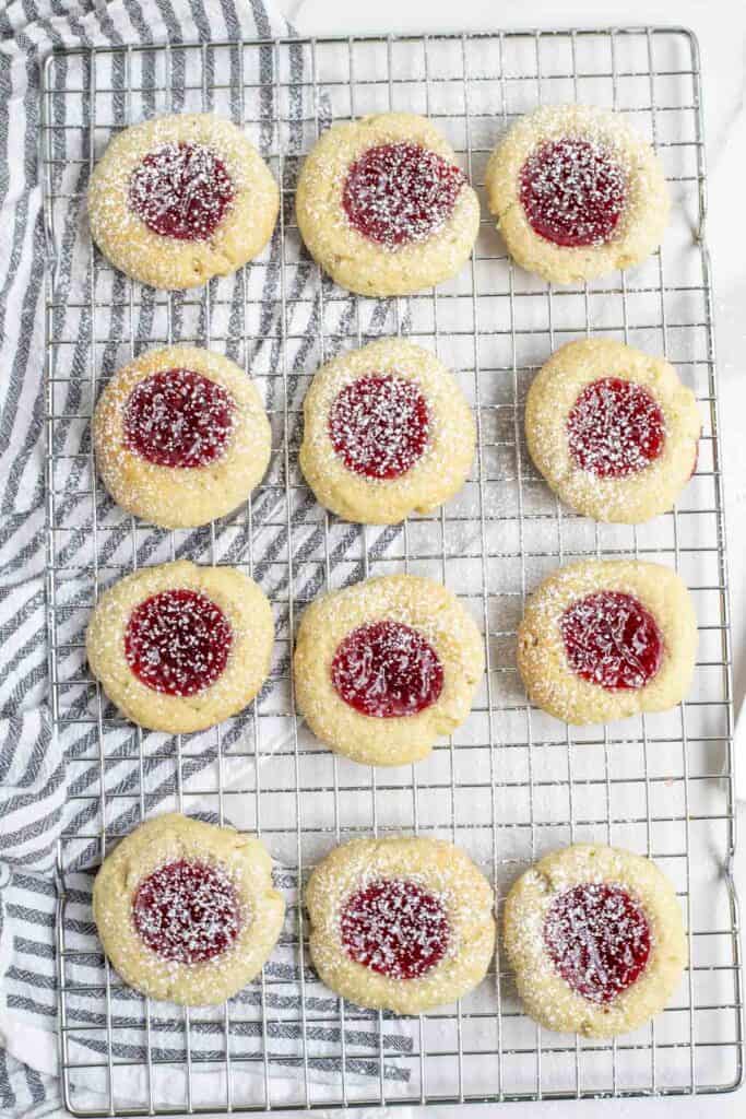 overhead photo of 12 sourdough thumbprint cookies on a wire rack