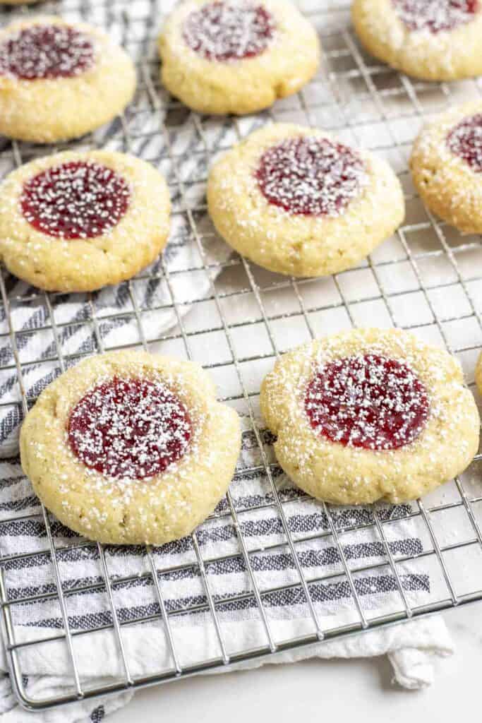 sourdough t thumbprint cookies on a wire rack on top of a black and white stripped towel