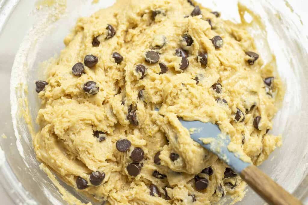chocolate chips folded into batter in a glass bowl.