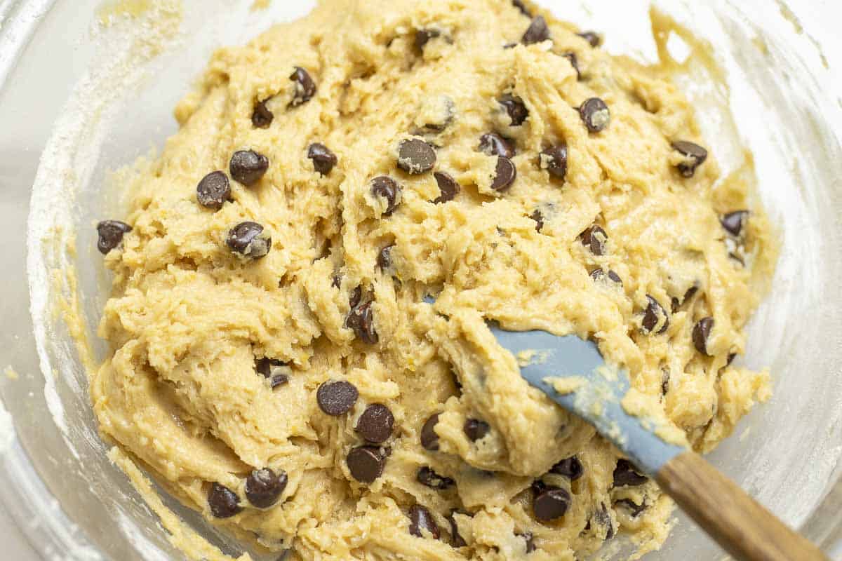 chocolate chips folded into batter in a glass bowl.