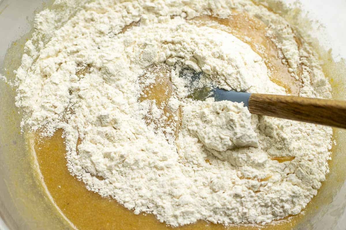 mixing dry ingredients into wet ingress in a glass bowl with a spatula