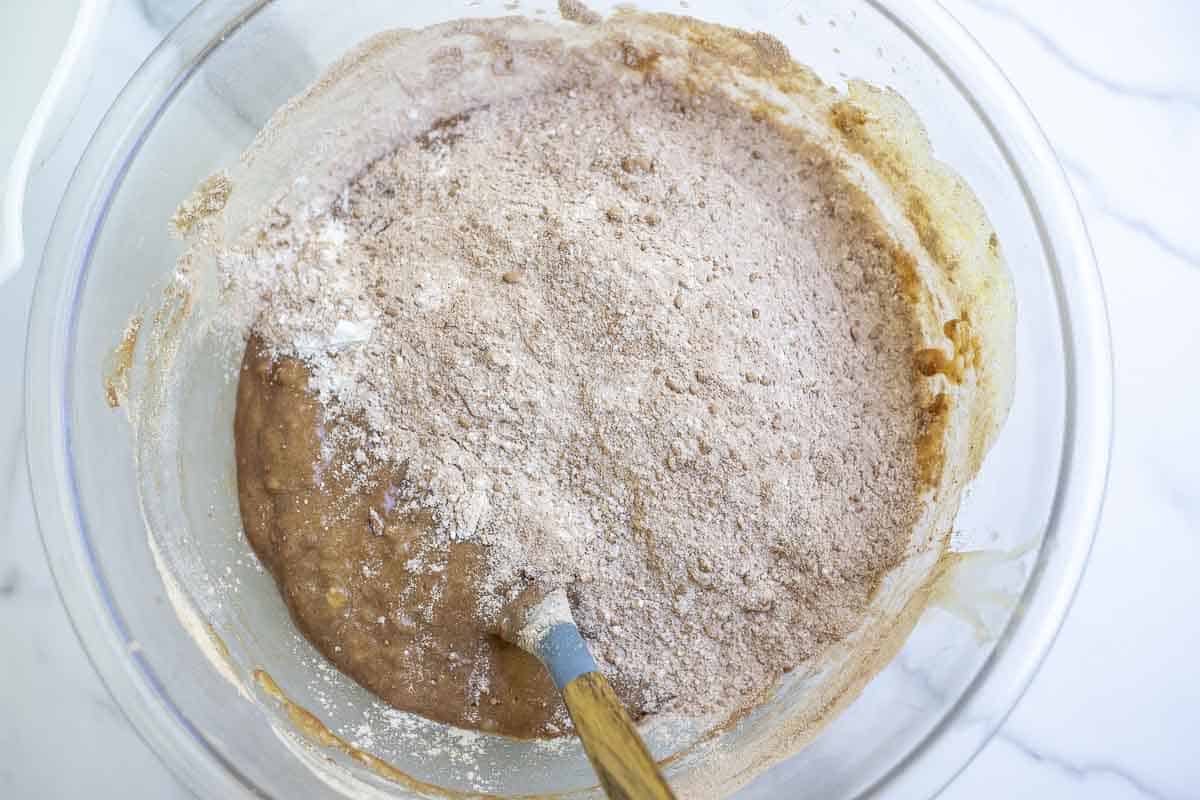 dry ingredients added to wet ingredients in a glass bowl
