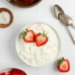 overhead photo of homemade cottage cheese topped with strawberry slices on a countertop.