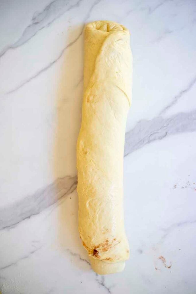 Filled cinnamon roll dough rolled into a log.