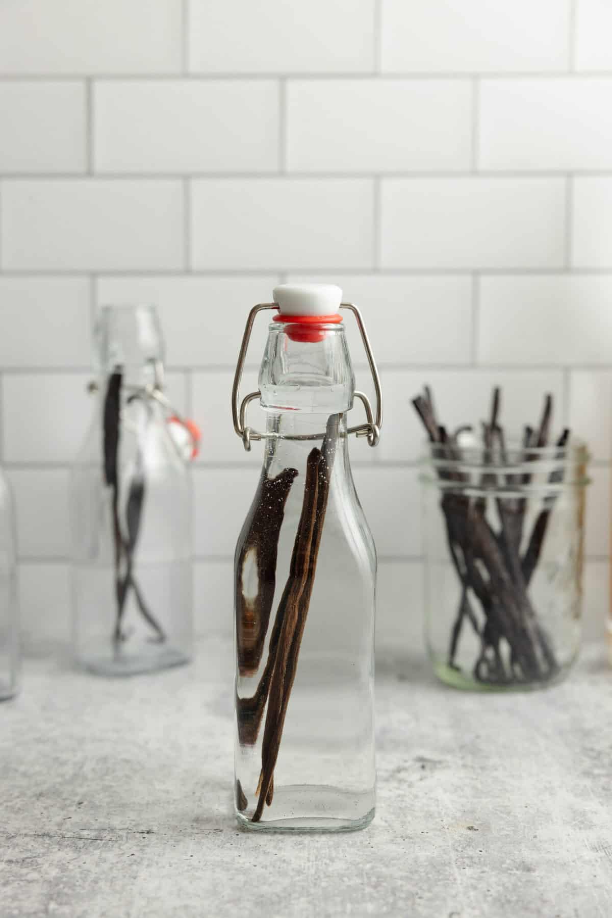 vodka and vanilla bean pods in a jar with a swing top lid.