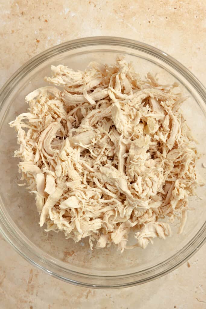 Shredded chicken in a clear bowl.