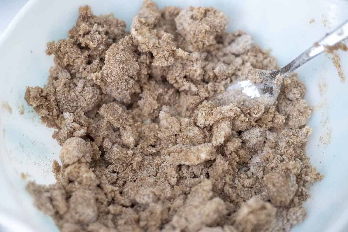 Mixing crumb topping in a bowl.