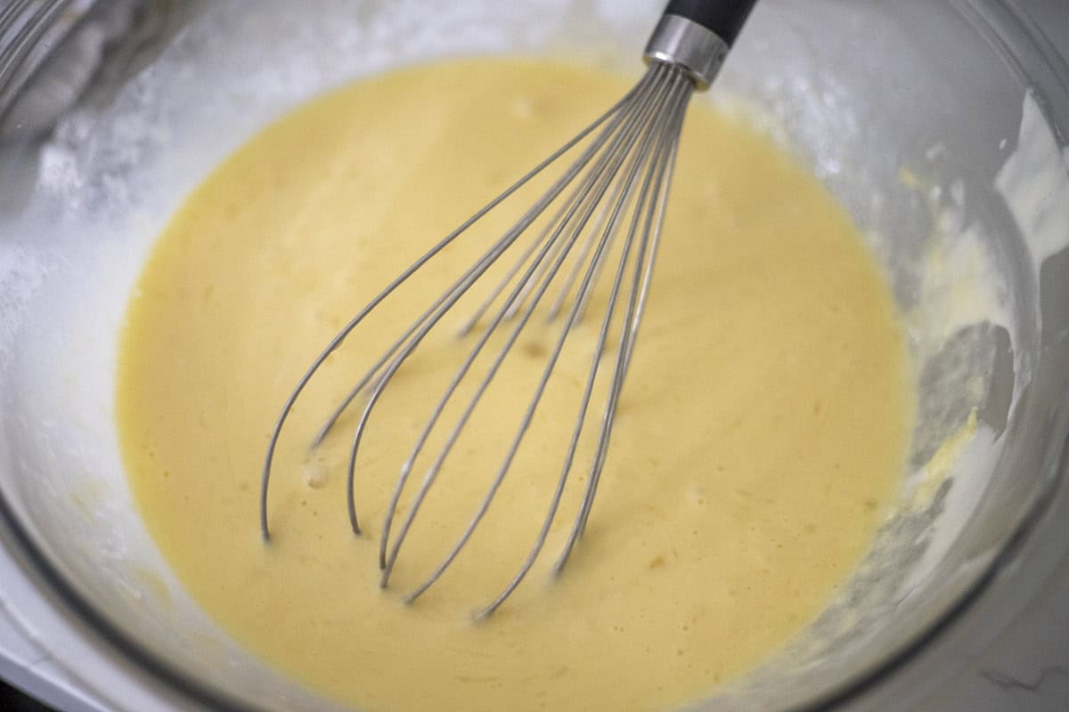 Sourdough crepes ingredients in a bowl with a whisk. 