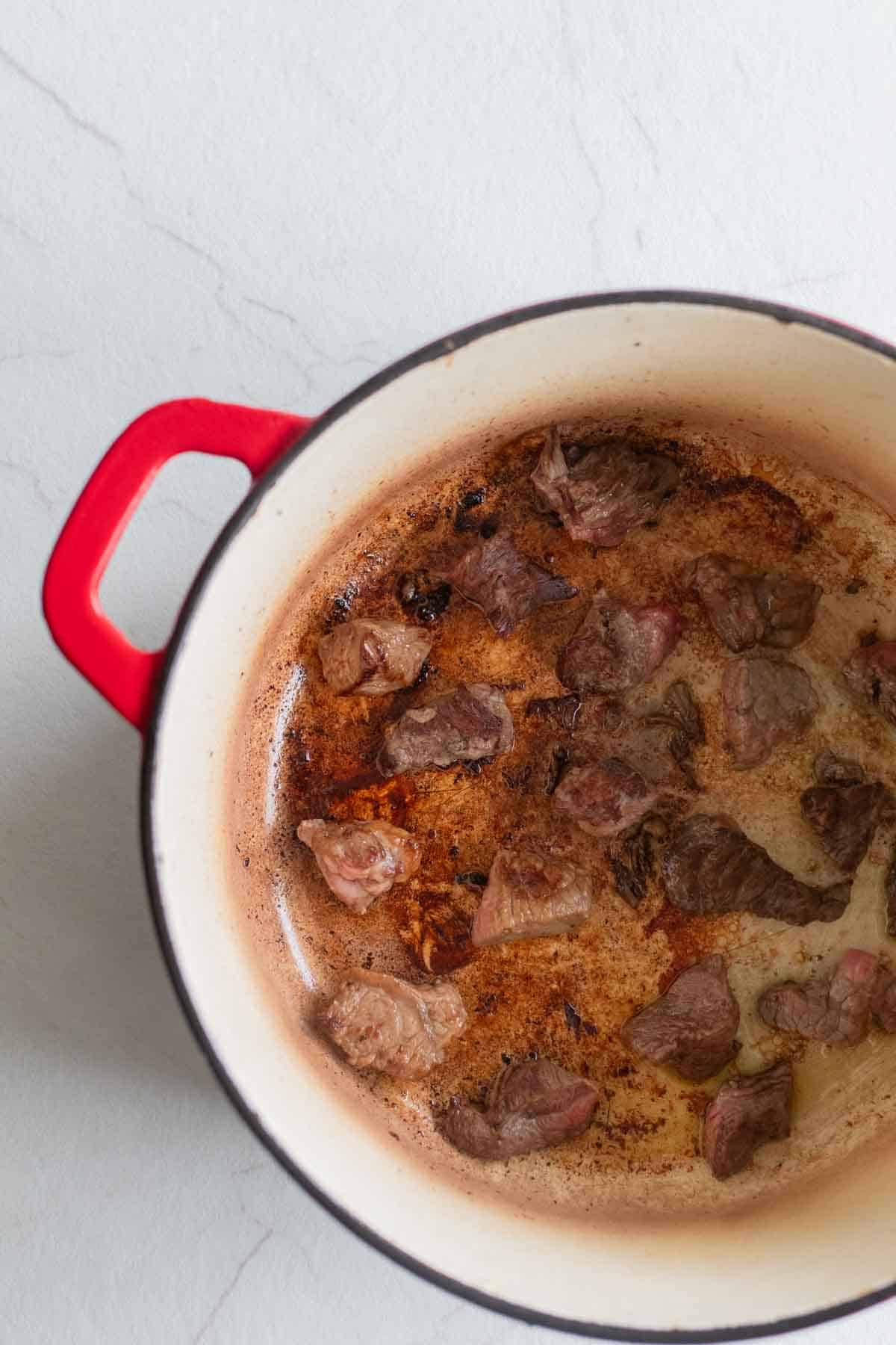 Beef browning in a Dutch oven.