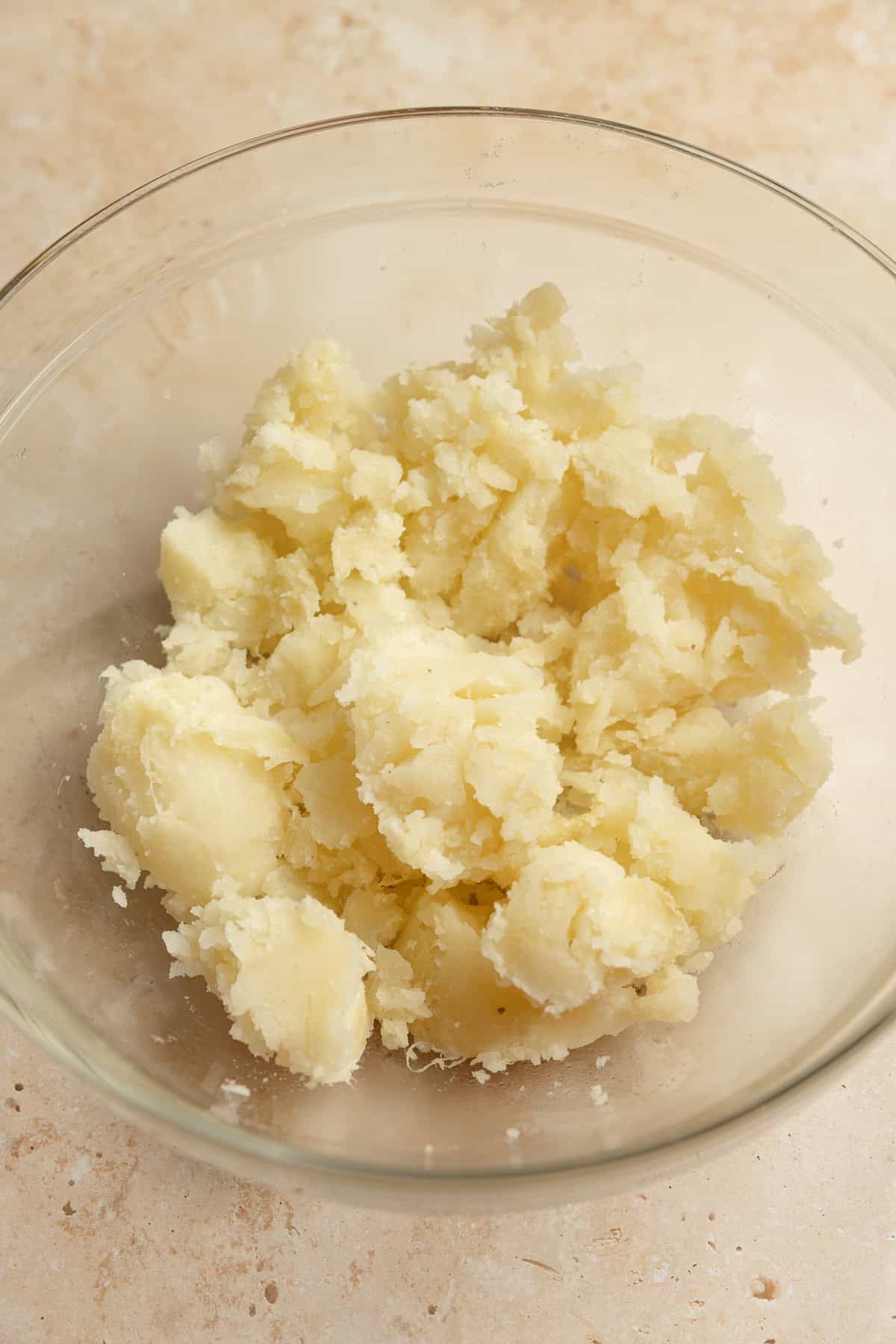 Cooked baked potato in a bowl with skin removed.