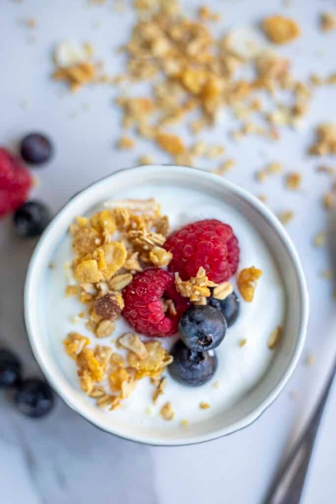 A bowl of yogurt topped with granola and fruit.