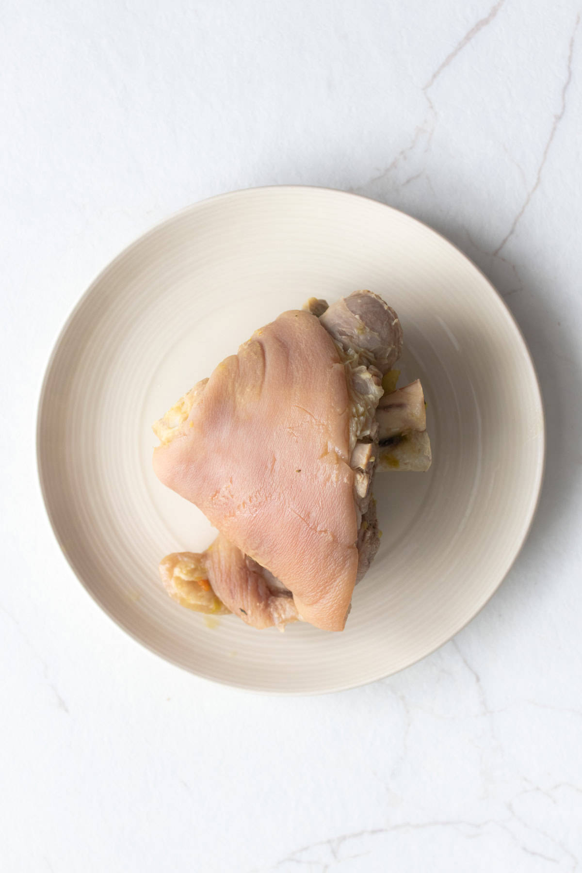 Cooked ham bone on a plate.