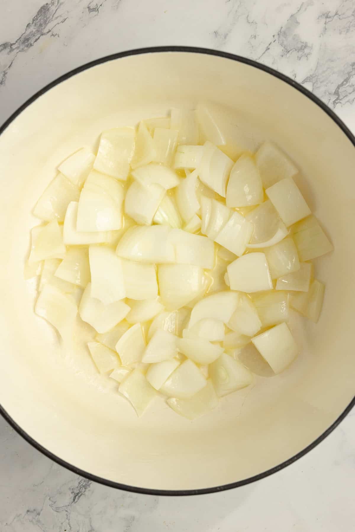 A Dutch oven with onions sauteing.