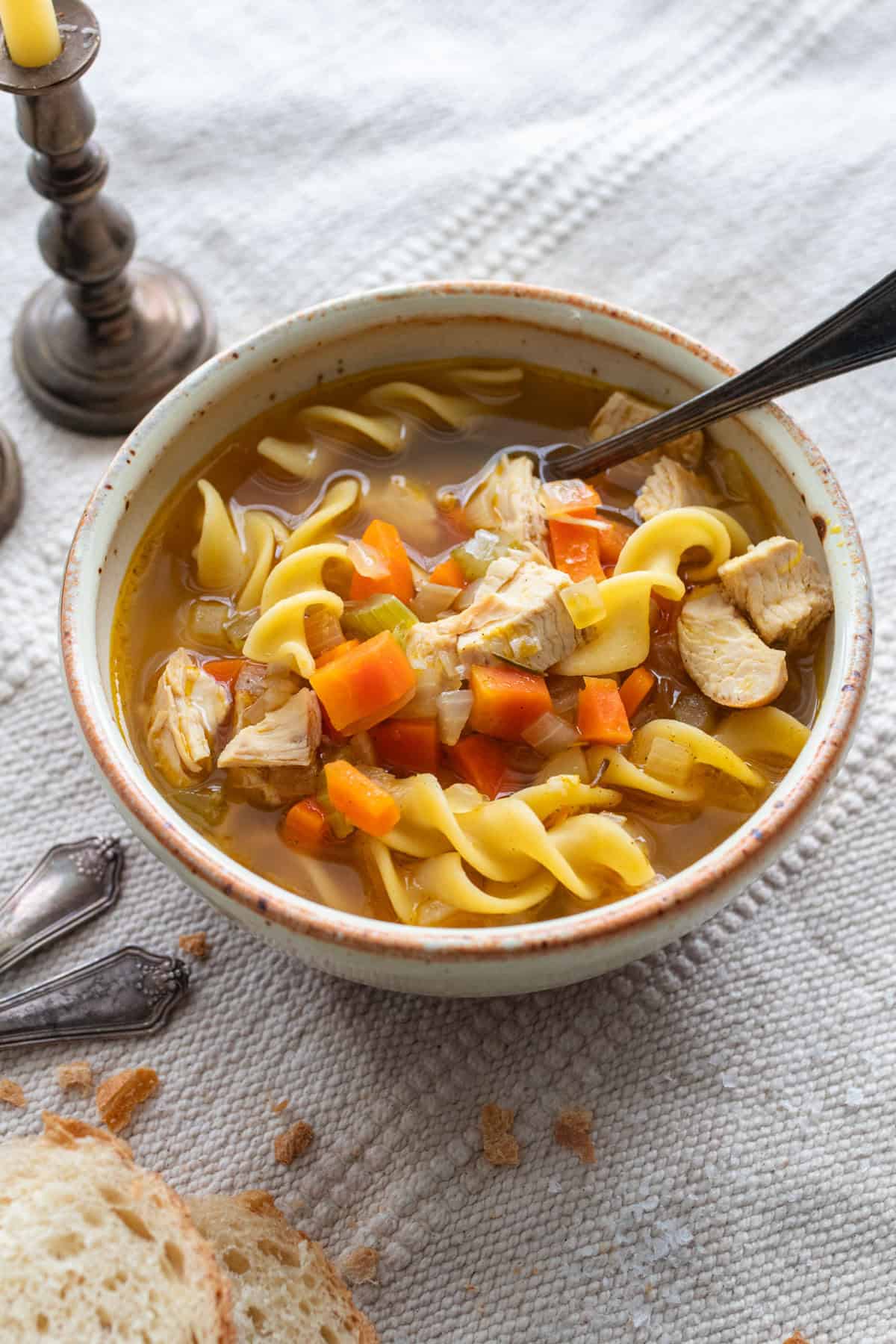 Bowl of chicken noodle soup with a spoon.