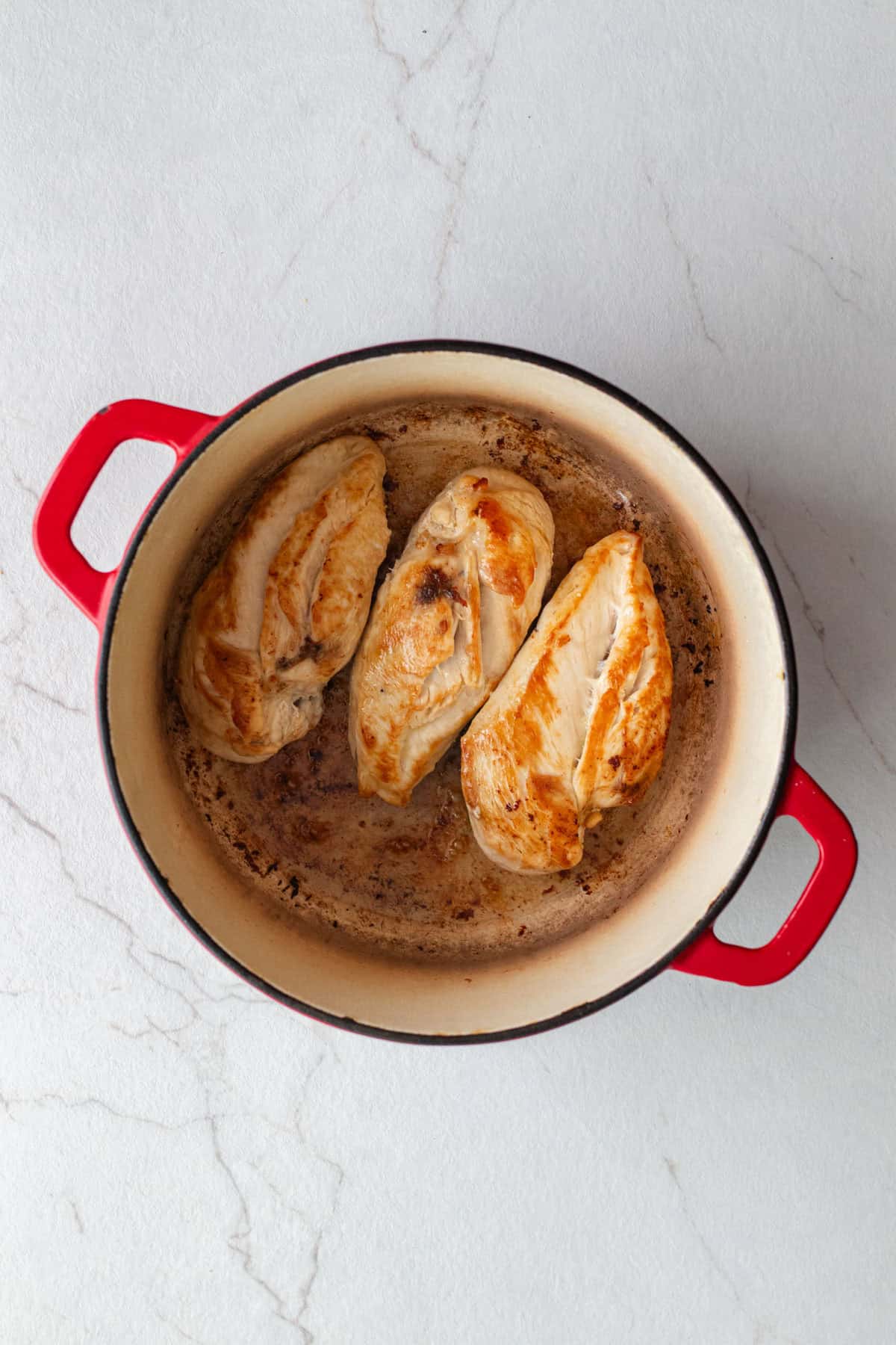 Cooking chicken breasts in a Dutch oven.