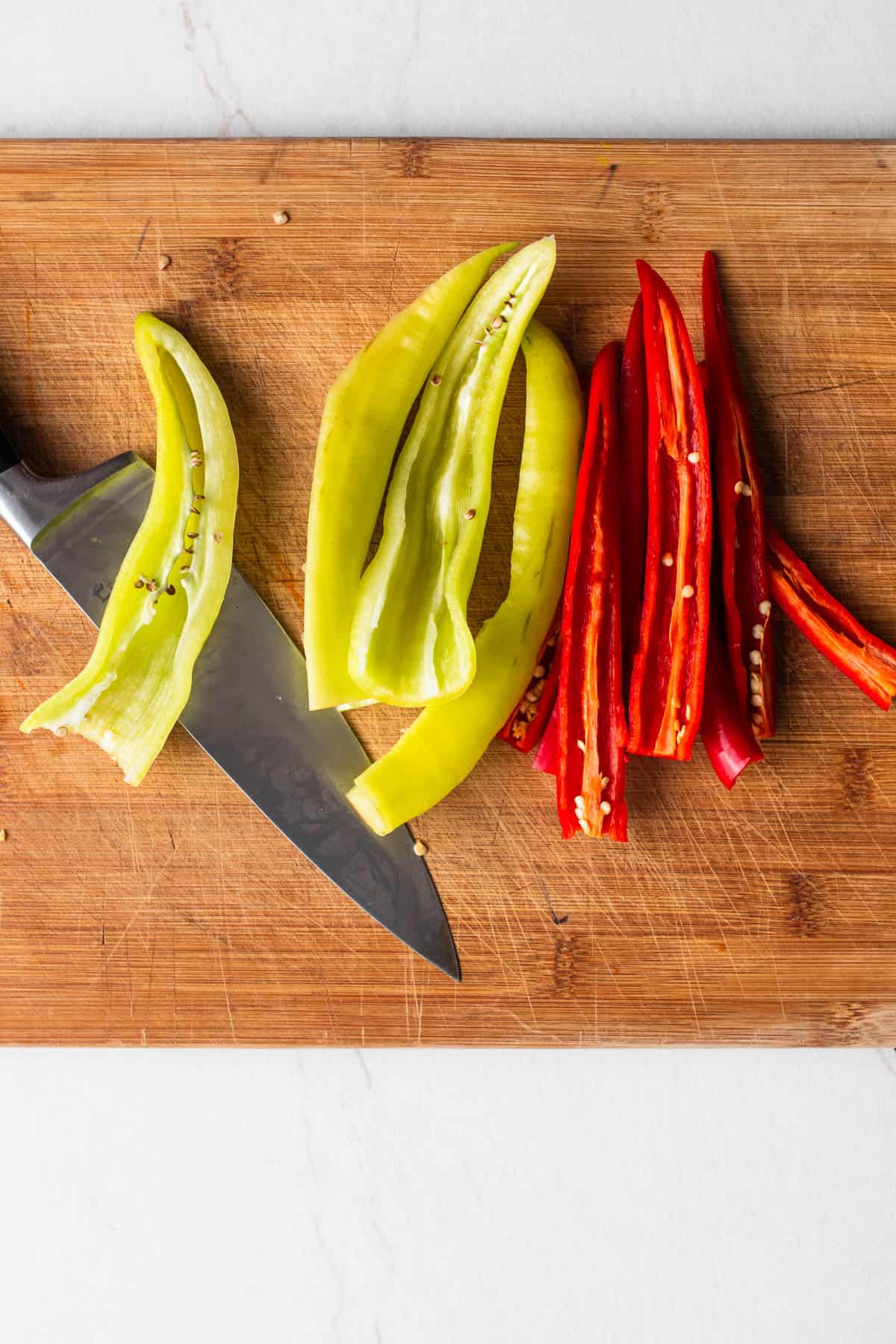 Peppers sliced on a wooden cutting board.