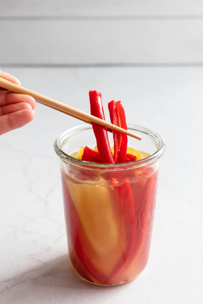 Fermented peppers being removed from a jar.