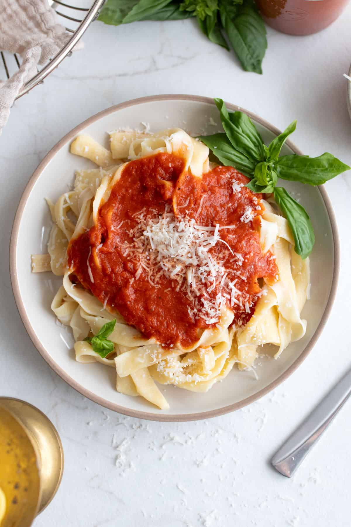 Pasta with sauce on top and herbs on the side.