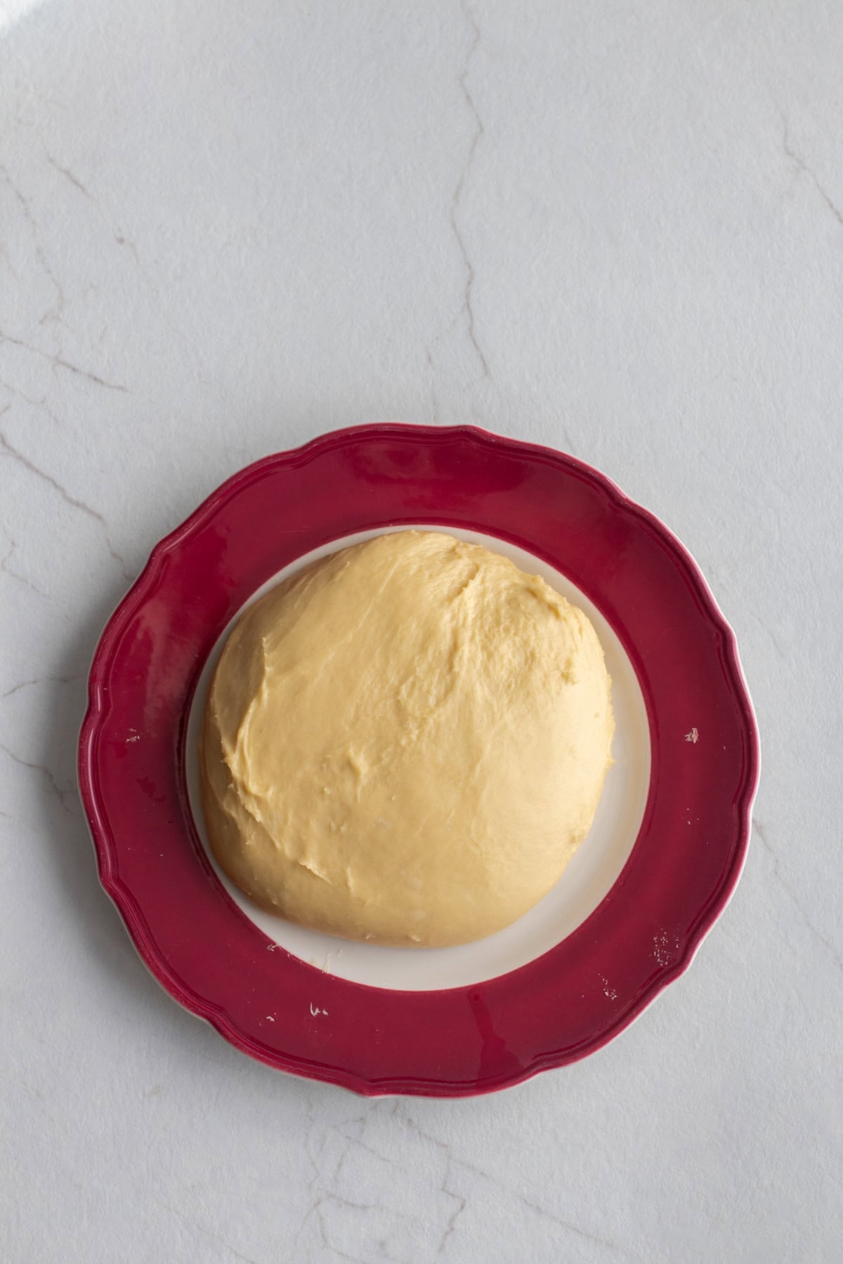 A dough ball resting on a plate.