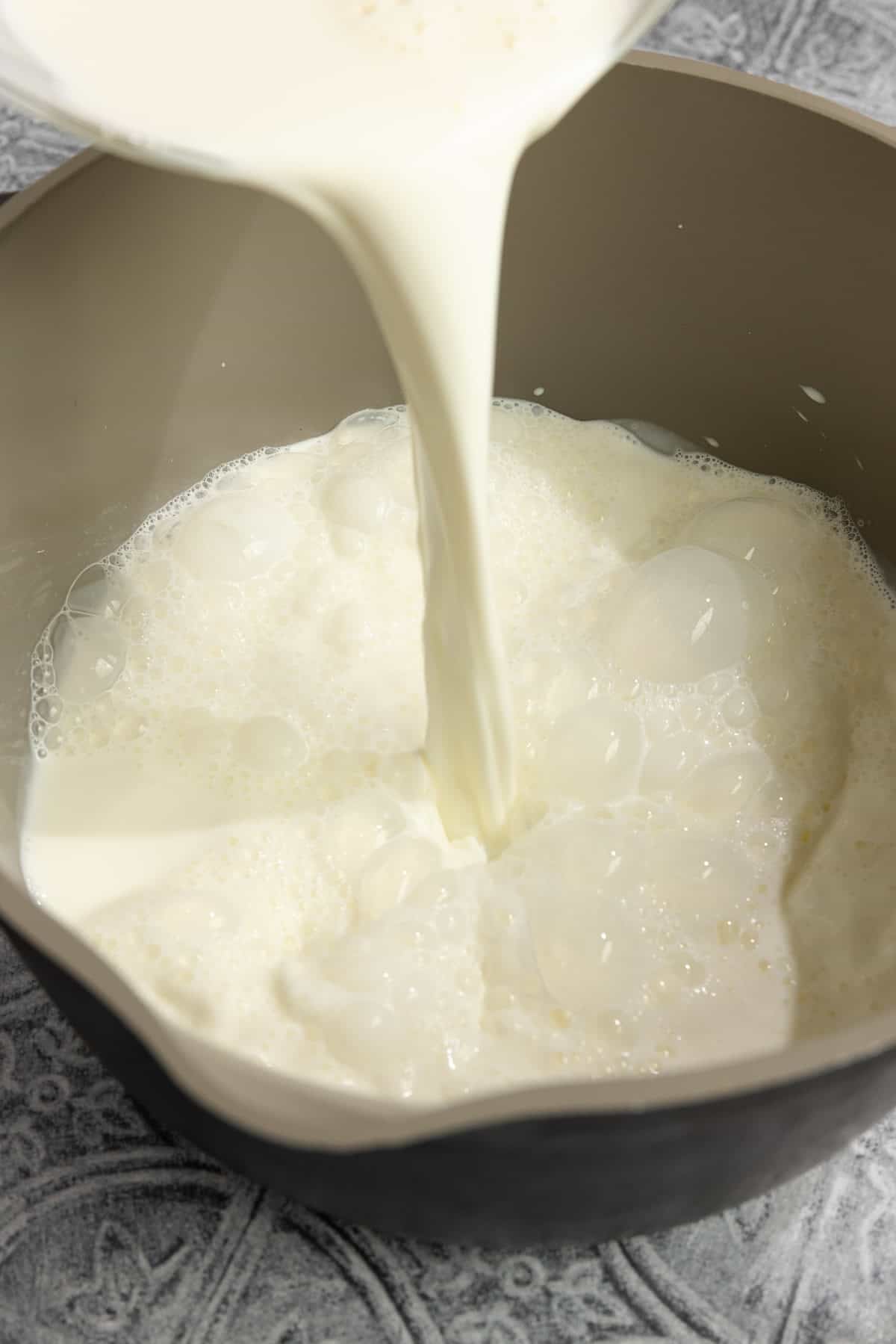 Pouring milk into a pot.