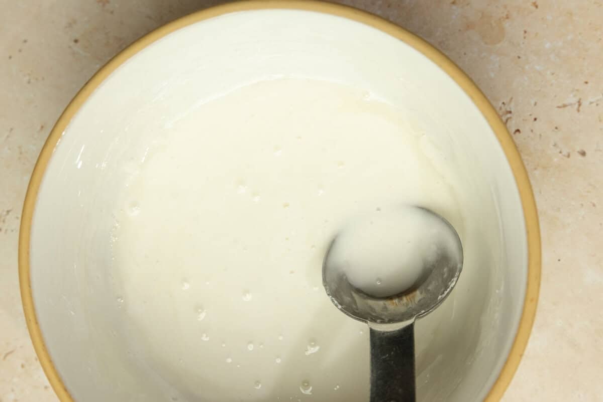 A bowl of royal icing with a spoon.