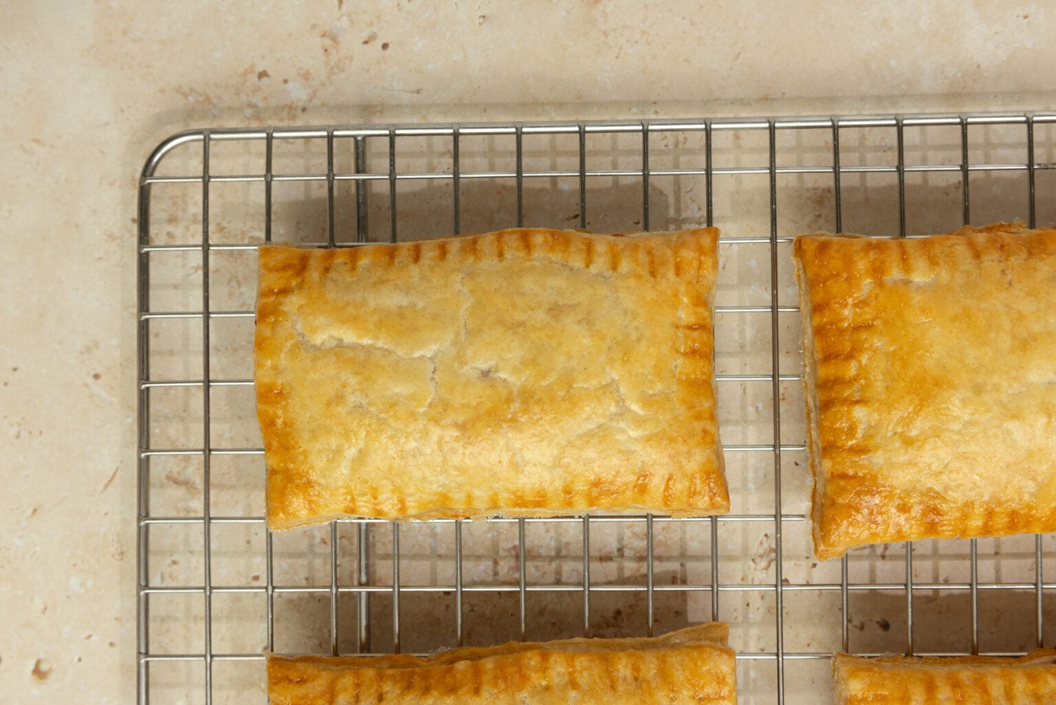 Fresh baked pop tarts right out of the oven on a rack.
