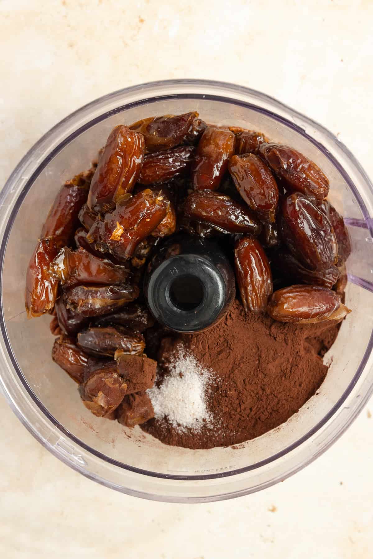 Dates, cocoa powder, salt, and pecans in a food processor.