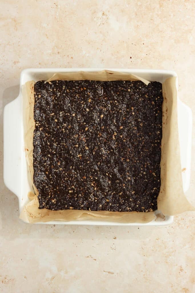 Date and nut mixture pressed in a 9x13 pan lined with parchment paper. 
