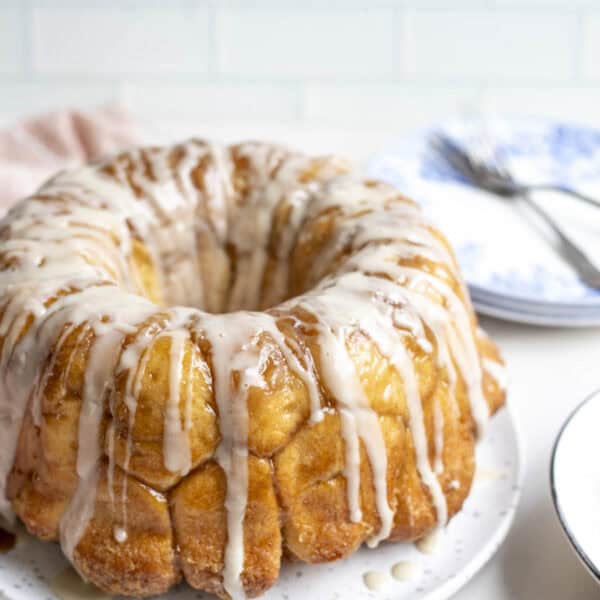 Sourdough monkey bread topped with icing on a plate.