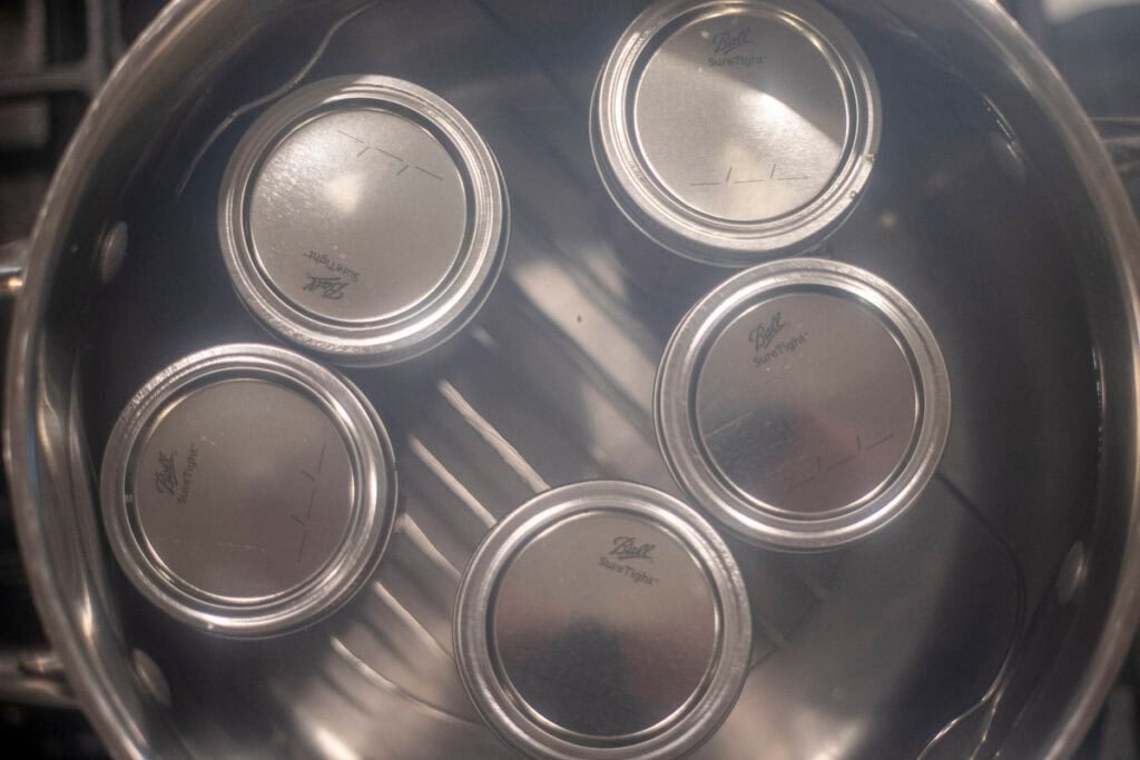 Jars with lids in a pot of boiling water.
