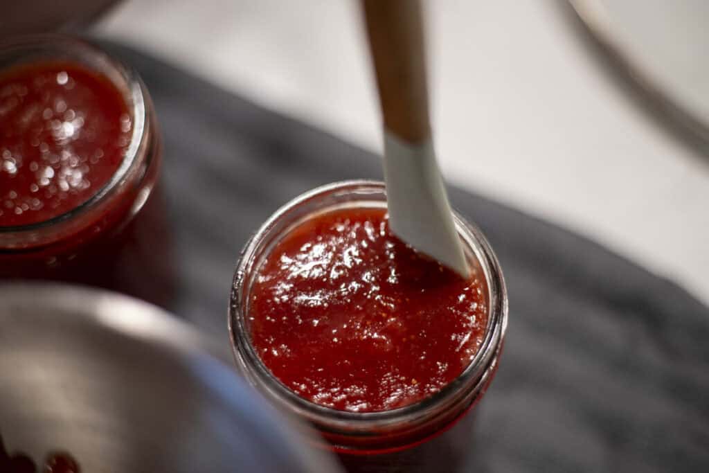 A rubber spatula in a jar of jam.