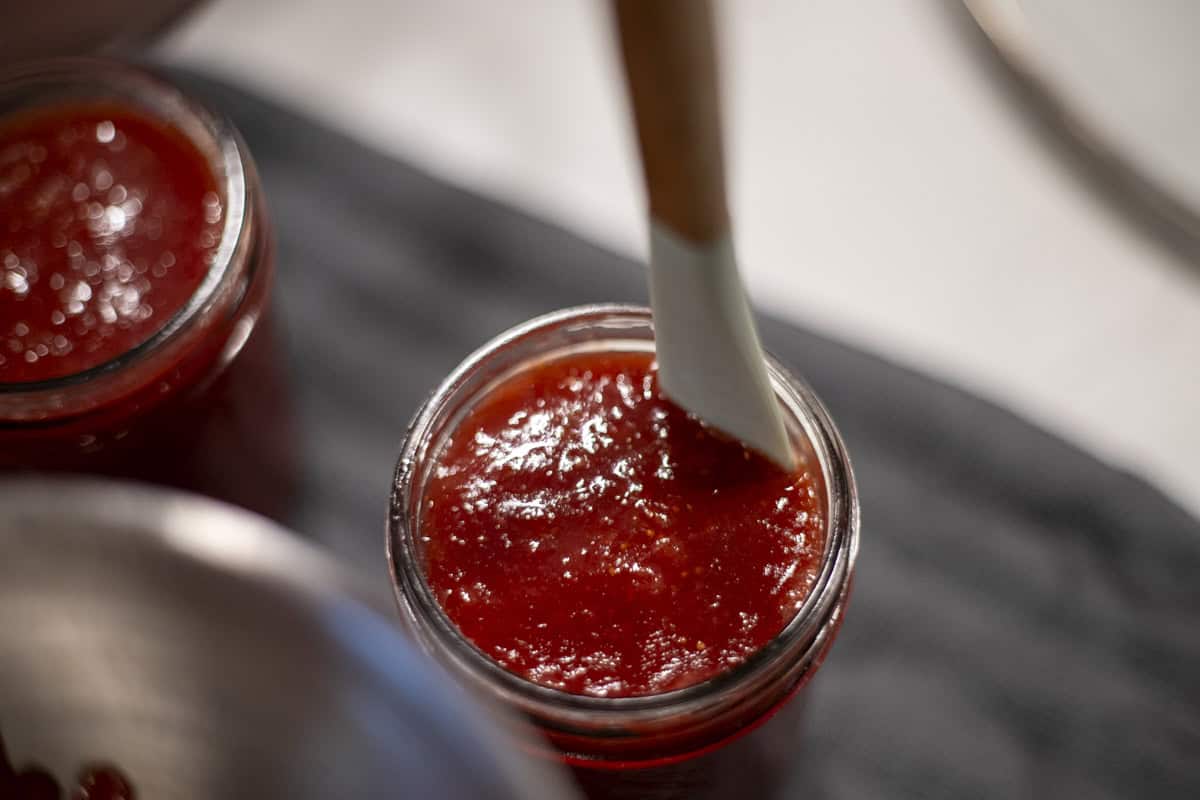 A rubber spatula in a jar of jam.