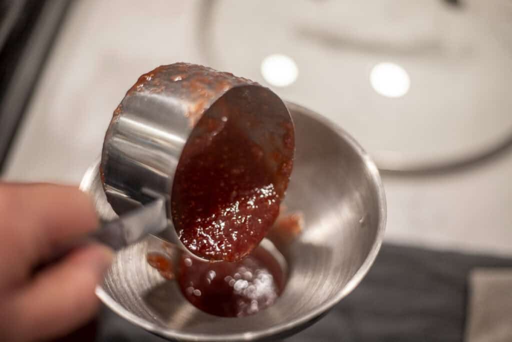 Strawberry jam added to jars.