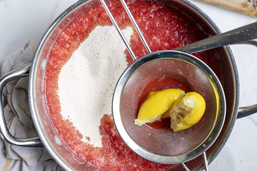 Ingredients added to blended strawberries in a large pot.
