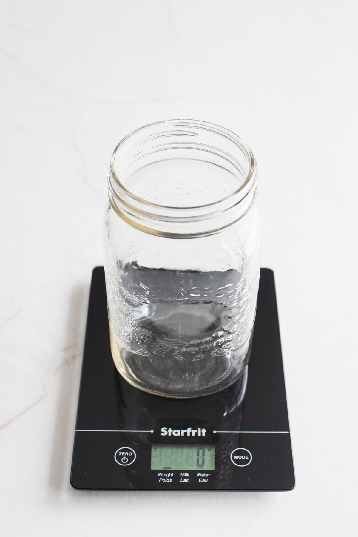 An empty jar on a kitchen scale.