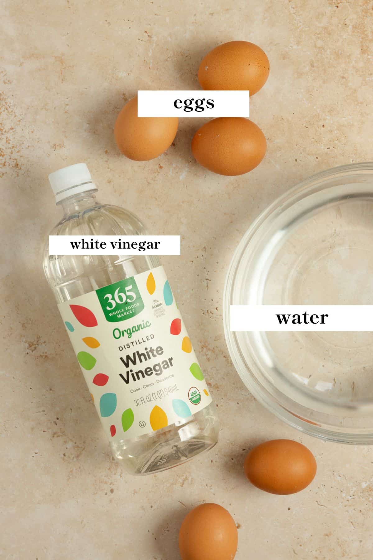 Eggs, water, and vinegar on a countertop.