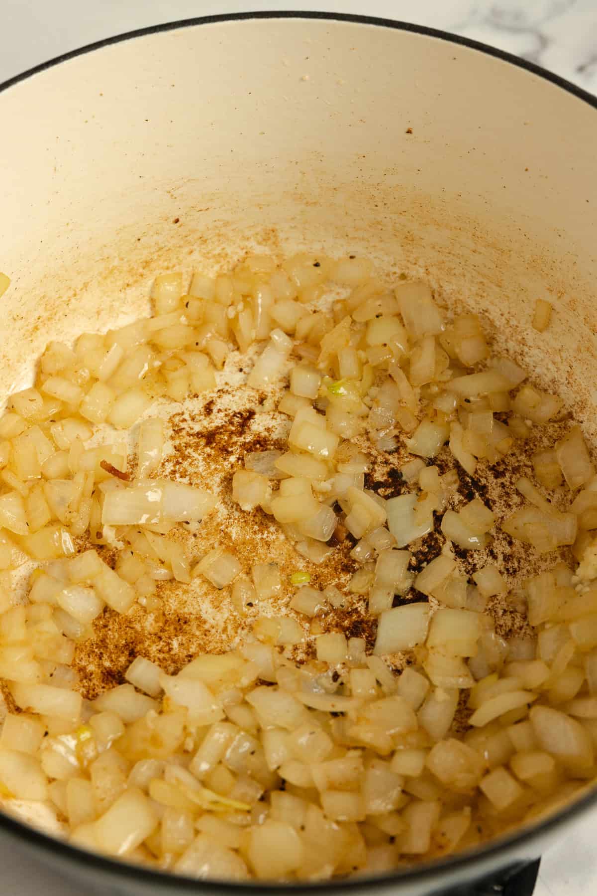 Sautéing onions in bacon fat in a pot.