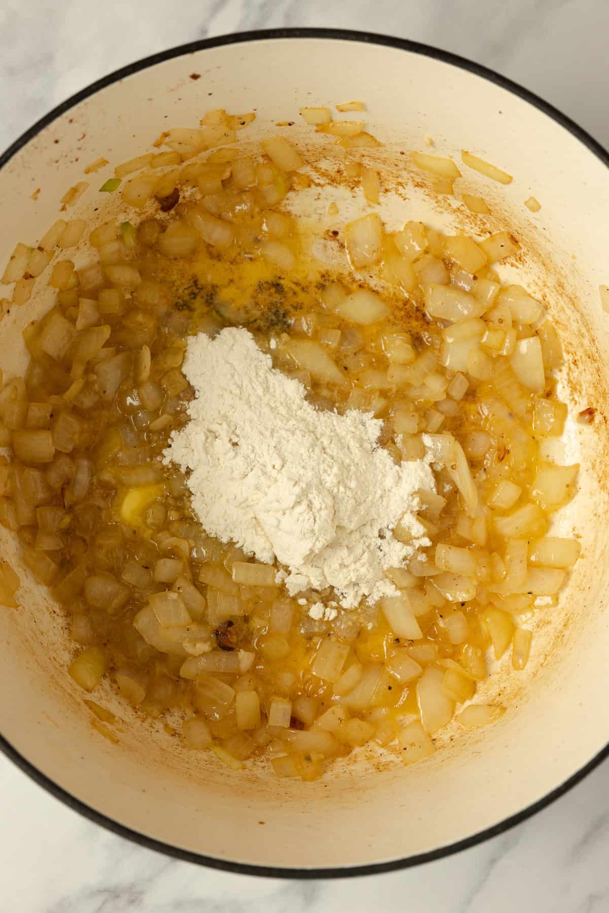 Butter and flour added to onions in a pot.