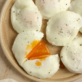 Poached eggs on plate with one cut in half.