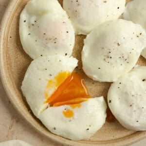 Poached eggs on plate with one cut in half.