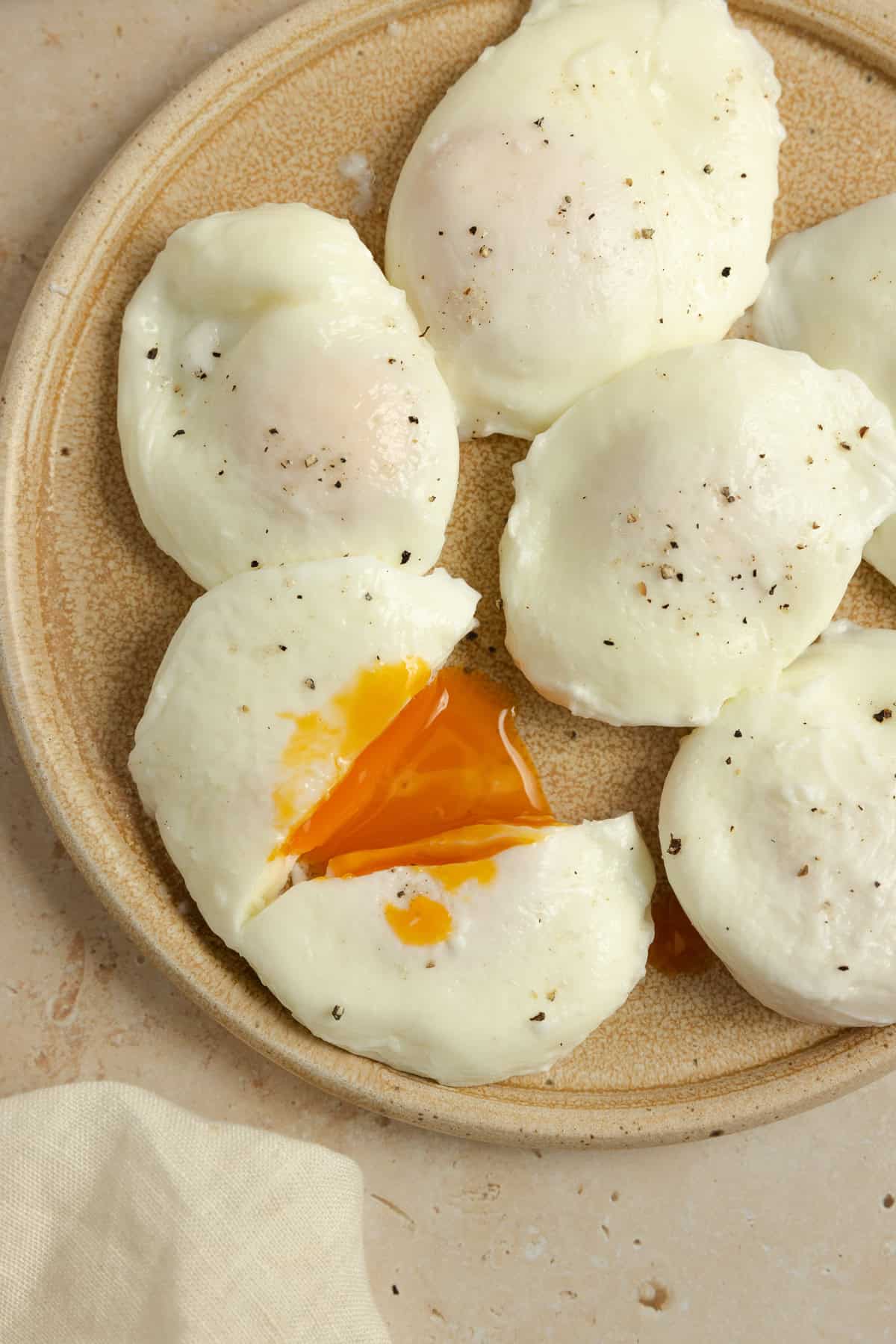 Poached eggs on plate with one cut in half.