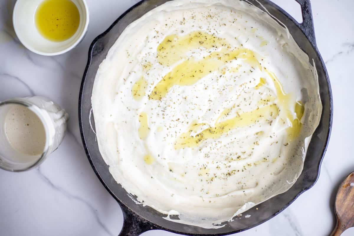 olive oil on sourdough starter in a cast iron skillet.