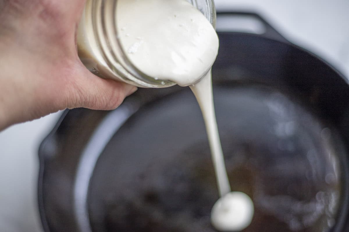 Sourdough starter poured into a hot cast iron skillet.