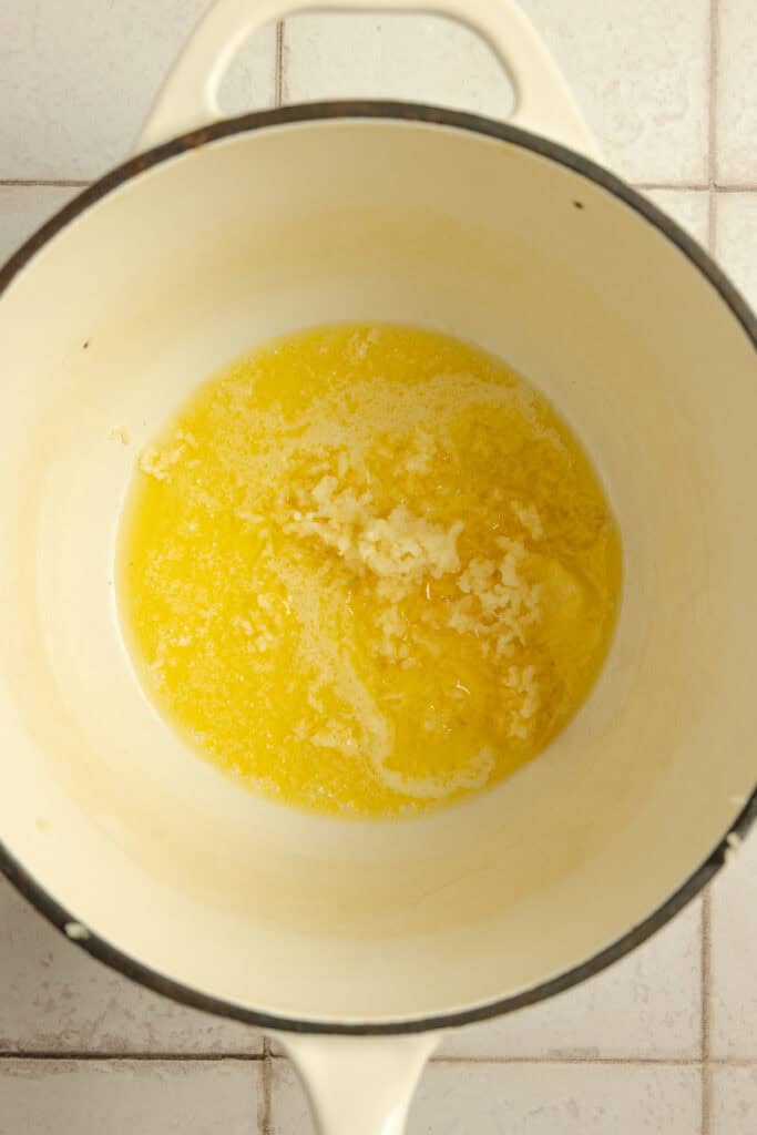 A sauce pot with melted butter and garlic.