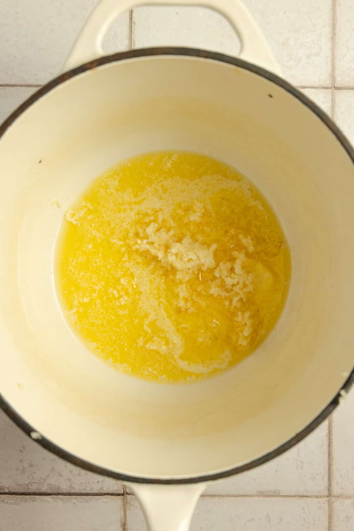 A sauce pot with melted butter and garlic.