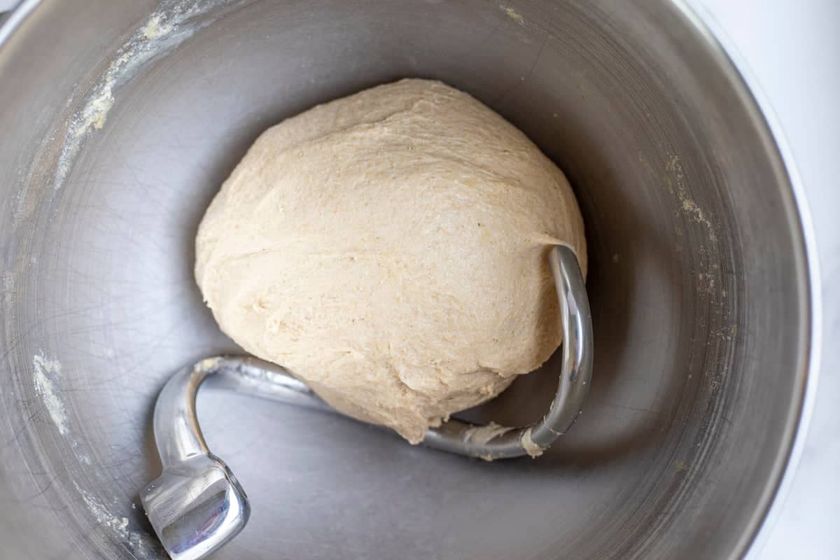 Whole wheat dinner rolls mixed in a stand mixer with a dough hook.
